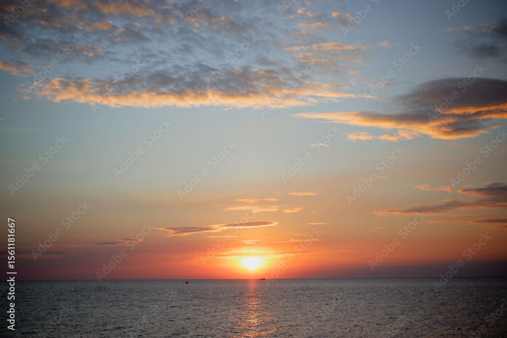 Obraz premium sunset in the sea. Beautiful colorful sky and cloud in twilight time background. Orange fluffy clouds and sun sunlight reflection in the blue