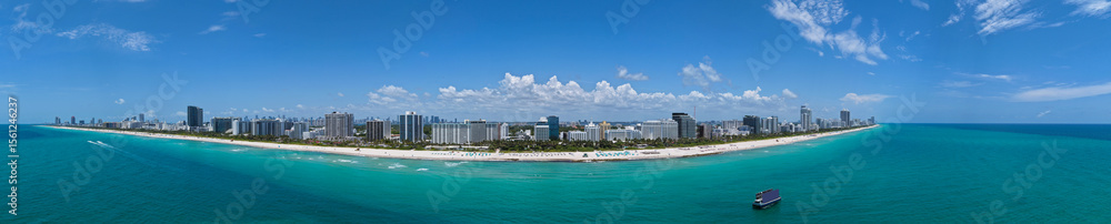 Naklejka premium Aerial view of South Beach coastline. Miami skyline with tropical blue waters panorama. Panorama over the Miami skyscrapers. Miami, Florida waterfront cityscape. Iconic South Florida travel