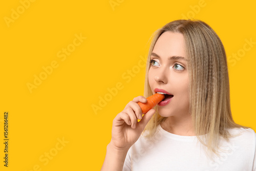 Young woman eating carrot o...