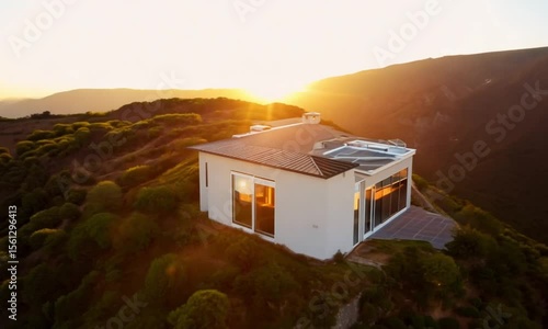 Wallpaper Mural Generate a smooth drone orbit around a minimal modern architecture house built into a hillside during golden hour, with clean lines, glass reflections, and surrounding natural elements. Use cinematic  Torontodigital.ca