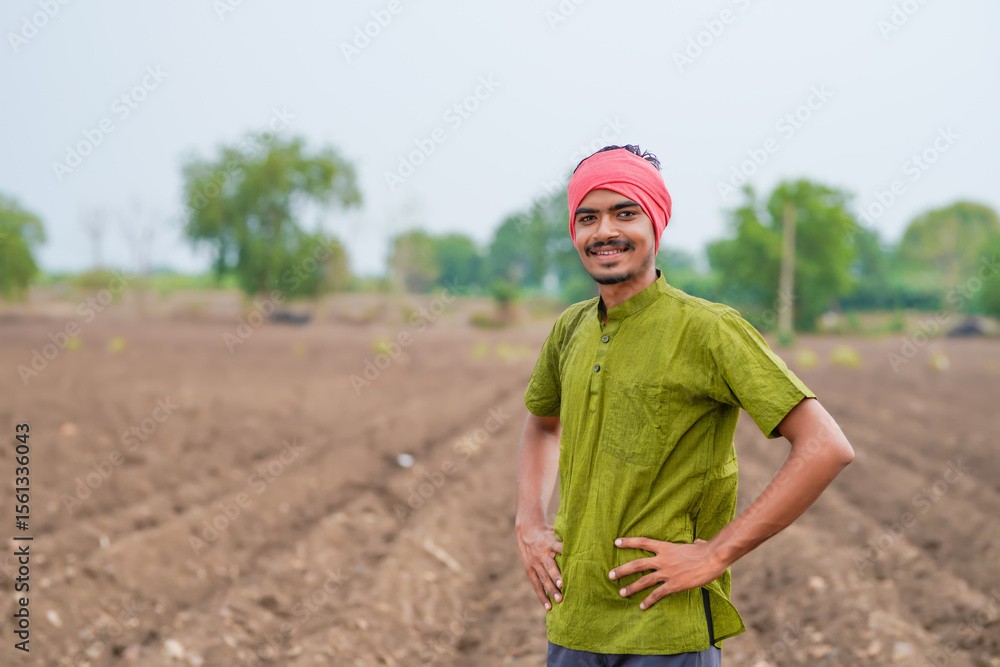 Fototapeta premium young indian farmer standing at agricultural field