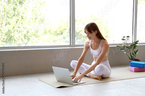 Sporty young woman using la...