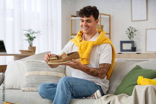 Young man cleaning suede sh...