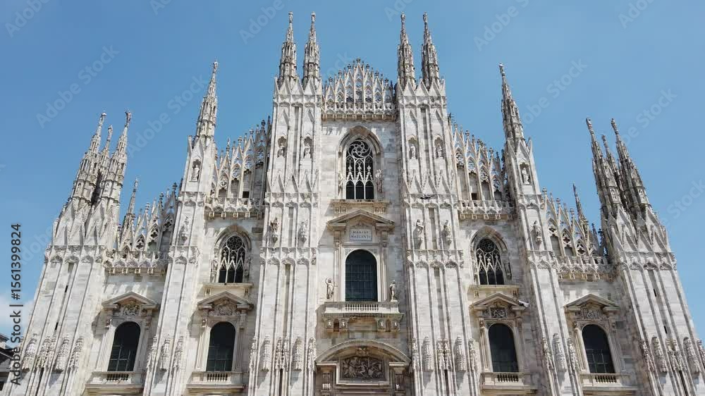 Milan duomo cathedral tilt up front view main facade gothic style against blue sly, tilt up Milan duomo cathedral tilt up front view main facade gothic style against blue sly, tilt up