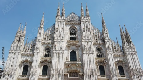 Milan duomo cathedral tilt up front view main facade gothic style against blue sly, tilt up