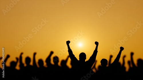 Silhouetted crowd is raising fists in protest at sunset, expressing their dissent and fighting for their rights in the fight against immigration raids