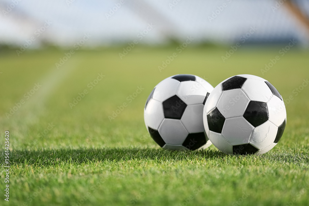 Fototapeta premium Soccer balls on green stadium grass, closeup