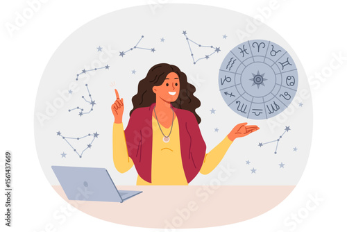 Woman astrologer tells fortunes by horoscope and predicts future by stars, standing near table with laptop. Girl astrologer points up, offering to read gorsk, standing near wheel with zodiac signs