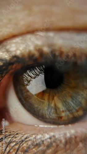 Macro video shooting of a female eye. The woman opens her eyes and looks. Slow motion