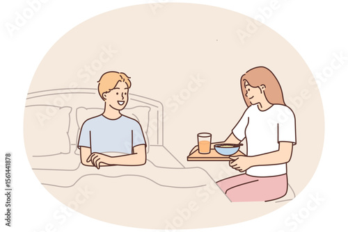 Caring wife brings breakfast to bed to beloved husband wanting to bring joy or caring during illness