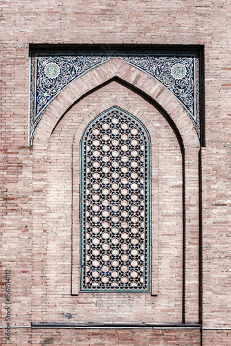 Ornate brick lattice window with floral tilework detail in Hazrati Imam mosque, Tashkent, Uzbekistan