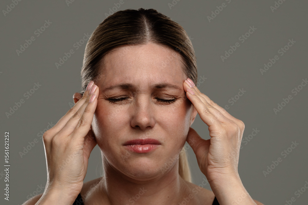 Woman Experiencing Headache with Hands on Temples Woman Experiencing Headache with Hands on Temples