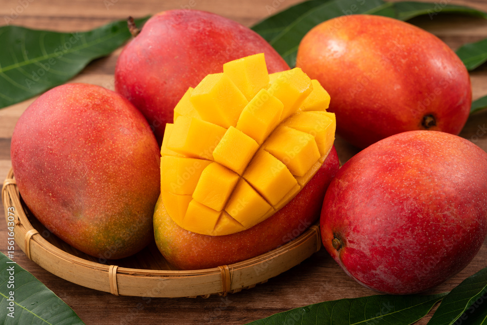Fresh ripe mango with cubes on wooden table background. Fresh ripe mango with cubes on wooden table background.