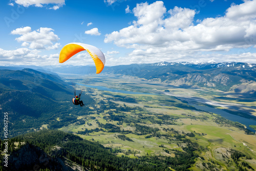 paragliding over scenic mountain valley with blue sky and clouds