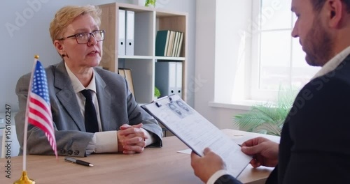 USCIS official specialist processing immigration naturalization applications helps man with paper documents. US citizenship approval, green card interview, USA visit, country residence permit concept