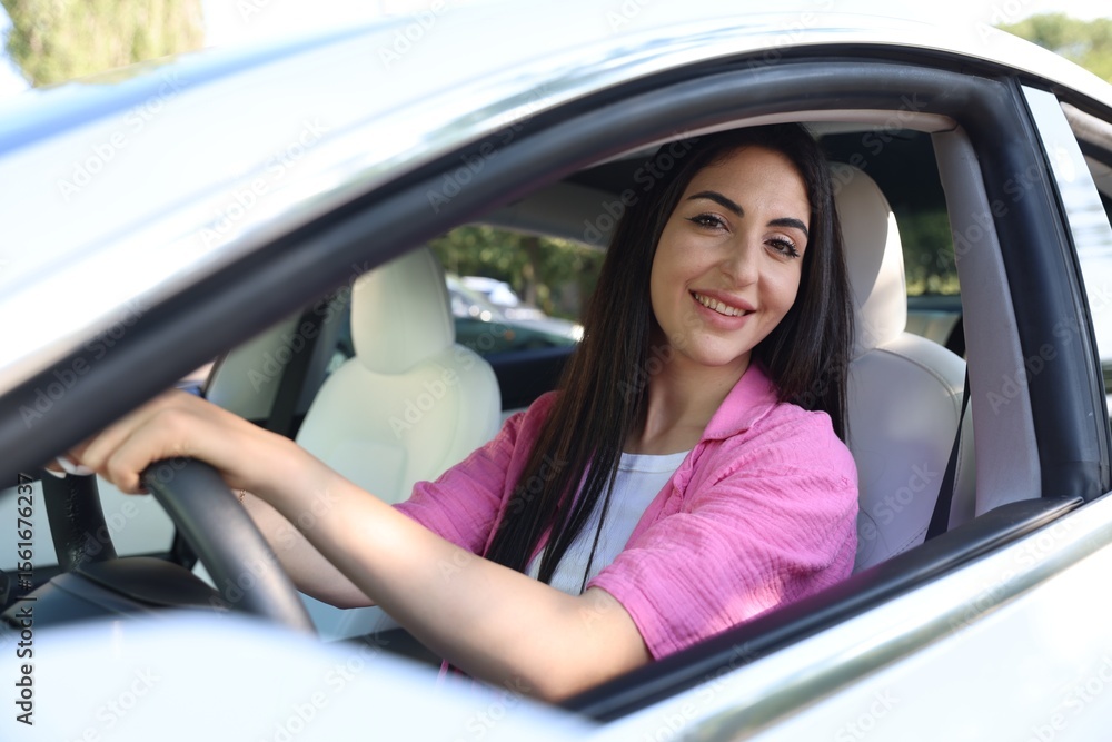 Woman behind steering wheel of modern car, view from outside Woman behind steering wheel of modern car, view from outside