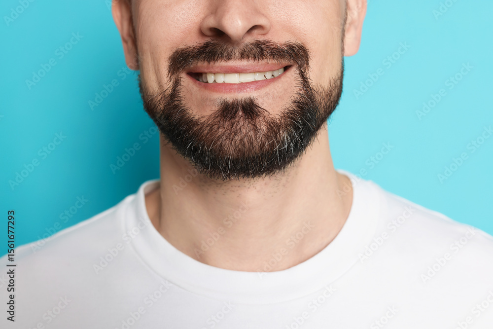 Fototapeta premium Smiling man before shaving on light blue background, closeup