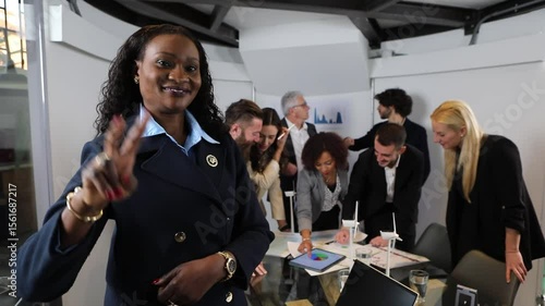 Confident businesswoman gesturing victory sign during meeting