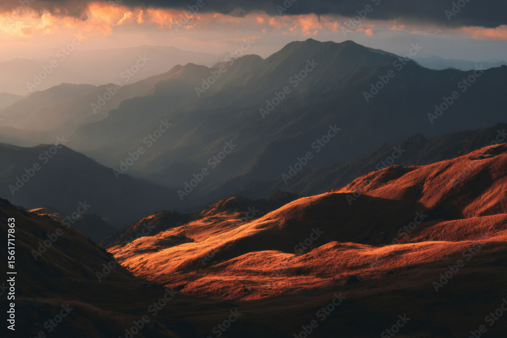 Naklejka premium Golden hour sunlight illuminates rolling hills and distant mountain ranges