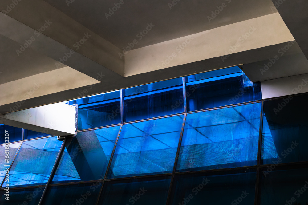 Fototapeta premium Modern architecture: blue glass facade with angular concrete elements