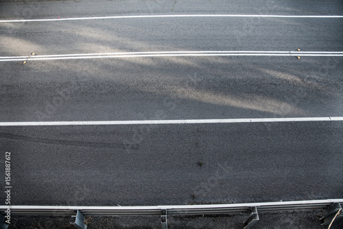Overhead shot of unbroken white lines on a sealed road