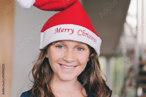 portrait of a tween girl wearing a christmas hat