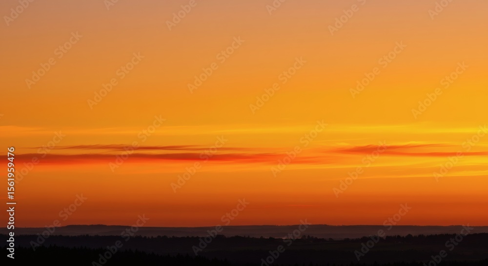 Naklejka premium Vibrant sunset over the horizon, showcasing warm colors and atmospheric layers.