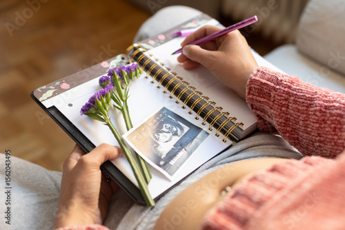 Pregnant woman writing in her diary