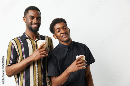 Принти на полотні Two black men enjoying coffee together, smiling brightly in casual clothing