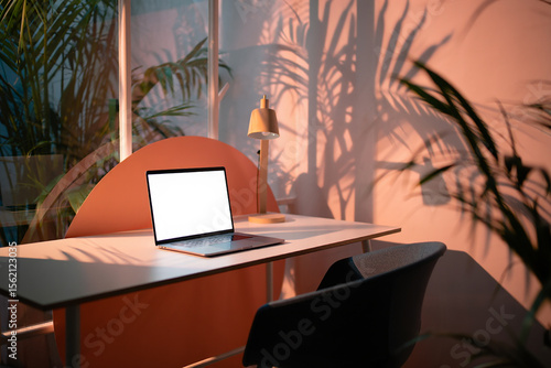 Cozy Workspace with Laptop Warm Lighting and Botanical Shadows a Modern Home Office Aesthetic for Work and Inspiration