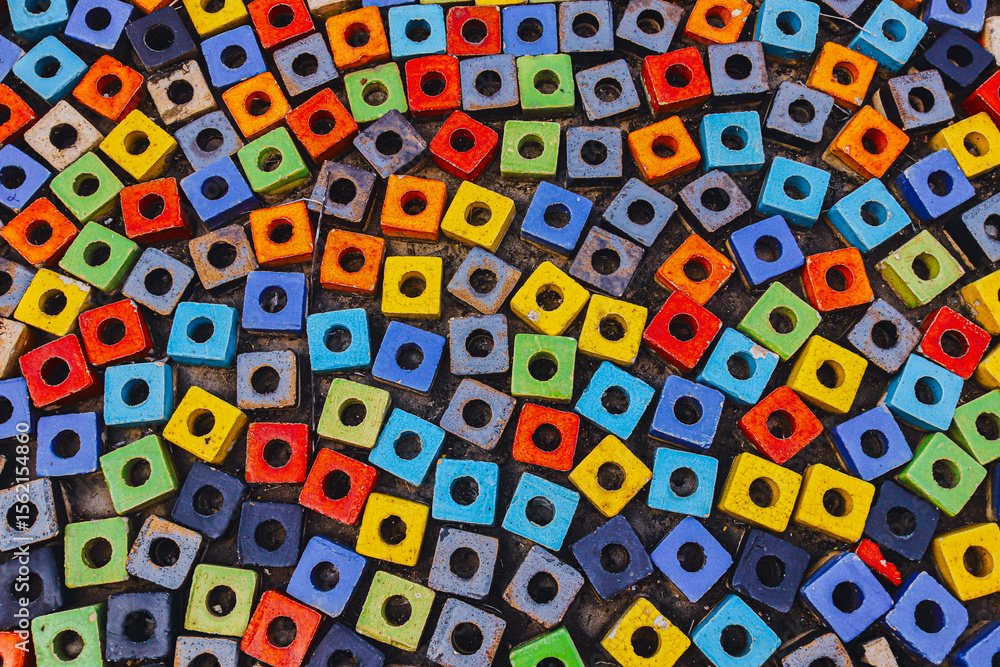 Close-up of public walkway paved with colorful hollow square beads arranged in artistic mosaic , abstract background texture symbolizing urban creativity and diversity. Close-up of public walkway paved with colorful hollow square beads arranged in artistic mosaic , abstract background texture symbolizing urban creativity and diversity.