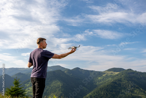 Obraz na plátne Man launching drone in mountain landscape
