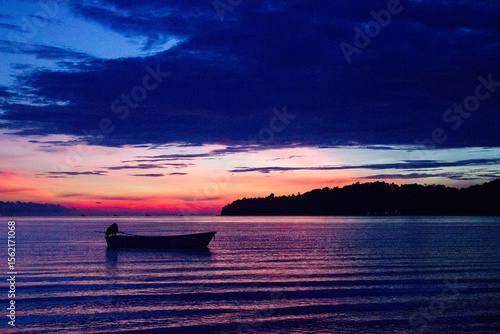 Foto Colourful sunset with silhouette of boat at Saracen Bay Beach, Kaoh Rong Sanloem