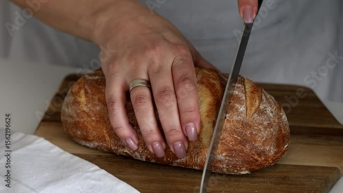 women's hands cutting homemade bread