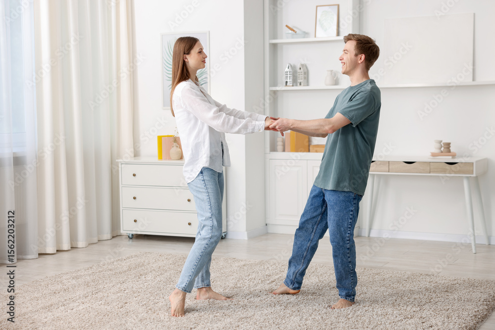 Obraz premium Happy young couple dancing together at home