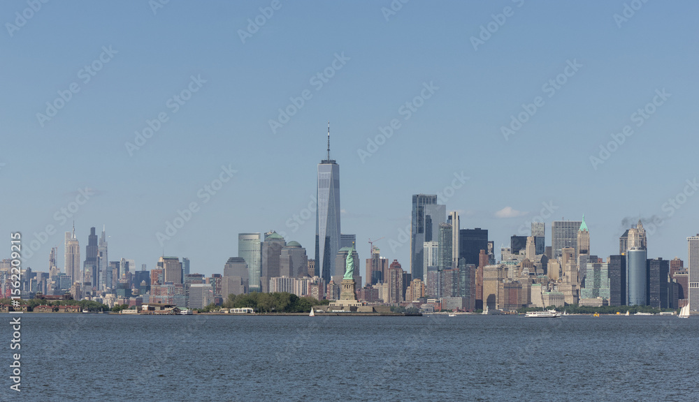 Fototapeta premium view of downtown manhattan skyline from liberty state park new jersey with statue and new york city skyscrapers (scenic travel destination metropolis) tourism holiday getaway summer of heat
