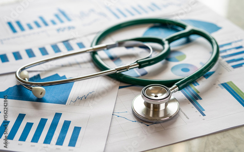 Medical stethoscope resting on financial charts illustrating healthcare data analysis and industry statistics in a business context.