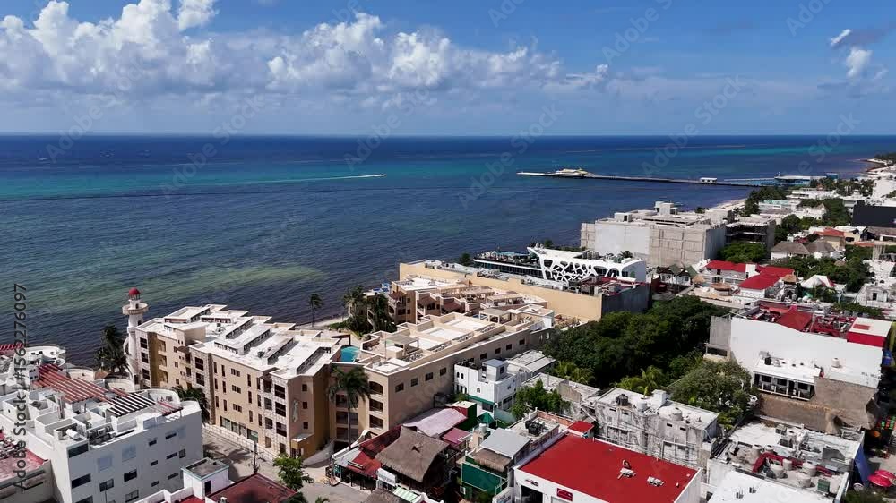 Aerial drone view of landscape in Playa del carmen with blue Caribbean Sea and buildings rooftop in the downtown area on a sunny day with blue sky and few clouds