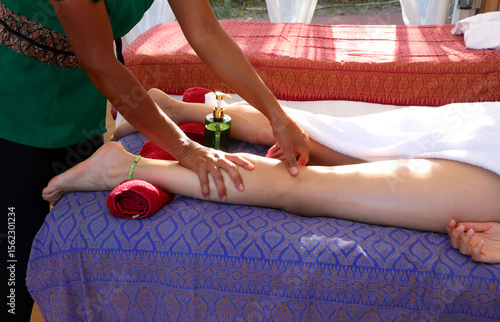 Fotografi strong hands of a Thai masseuse massaging the pulp of a young woman during a dra