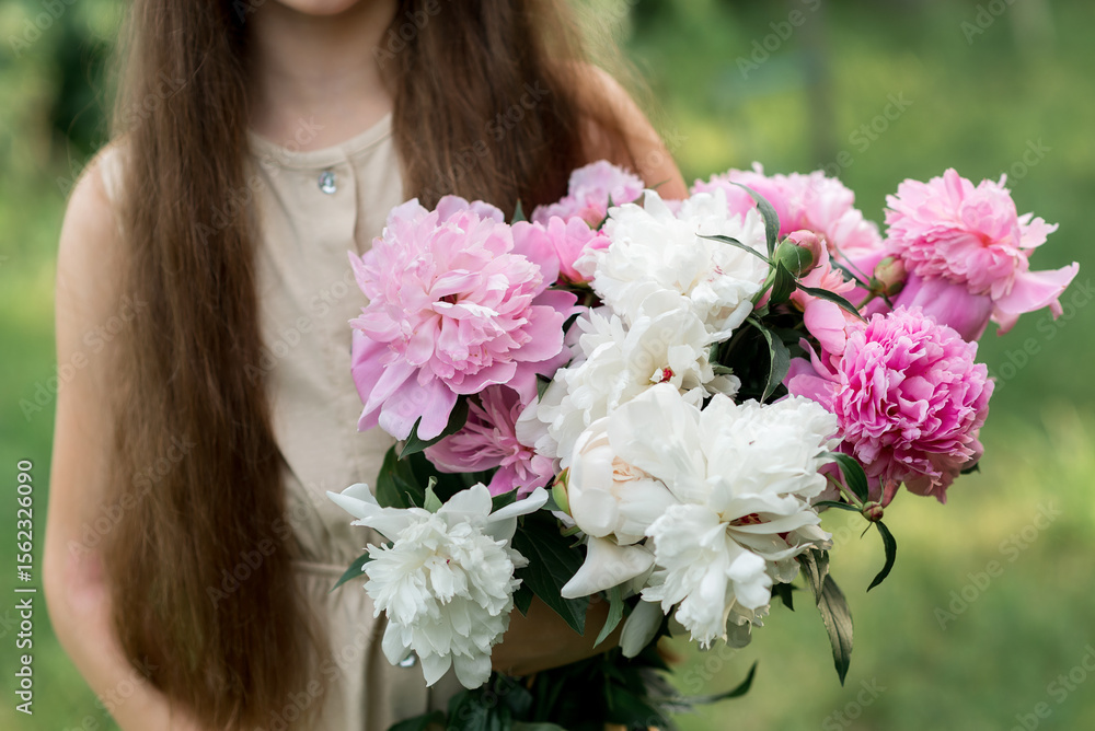 girl holding pink flowers peonies in the garden girl holding pink flowers peonies in the garden