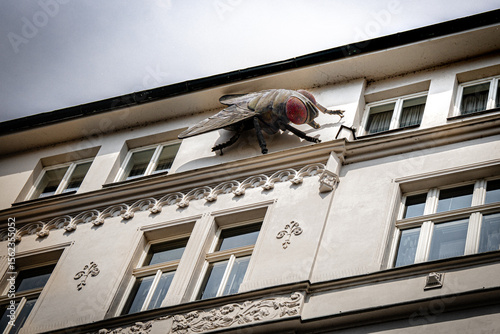 Large fly sculpture on historic building facade in Prague, Czech Republic – Editorial use only