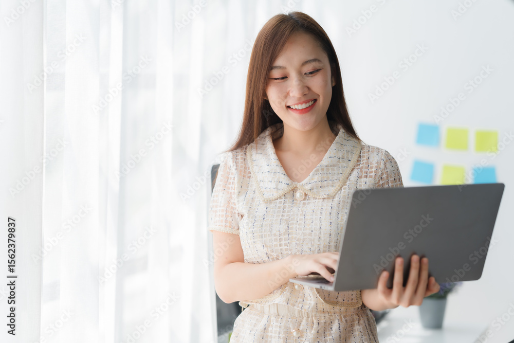 Smiling Professional with a Laptop: A professional woman is working on a laptop in a modern office environment, her smiling expression reflecting professional competence. Smiling Professional with a Laptop: A professional woman is working on a laptop in a modern office environment, her smiling expression reflecting professional competence.