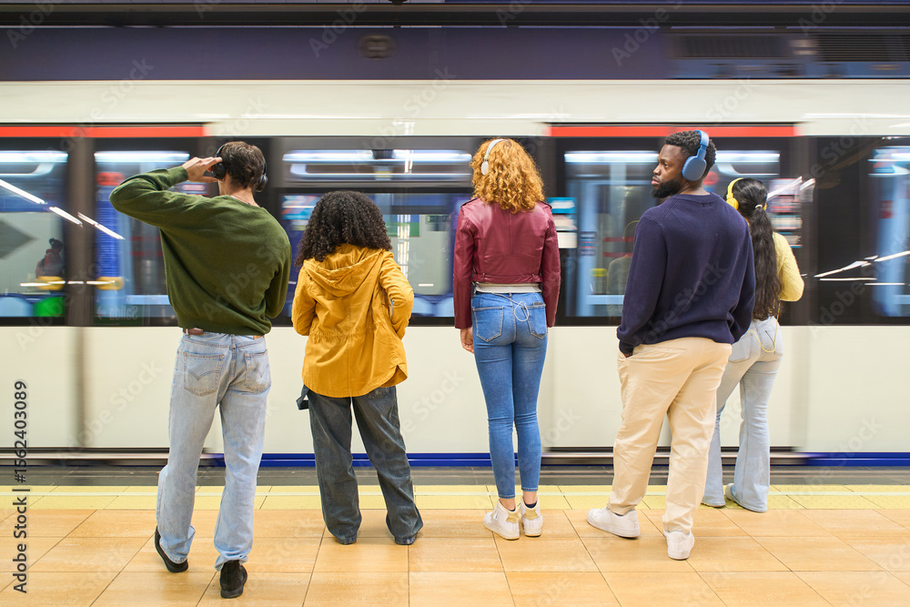 Fototapeta premium Young people waiting for arriving train in subway station