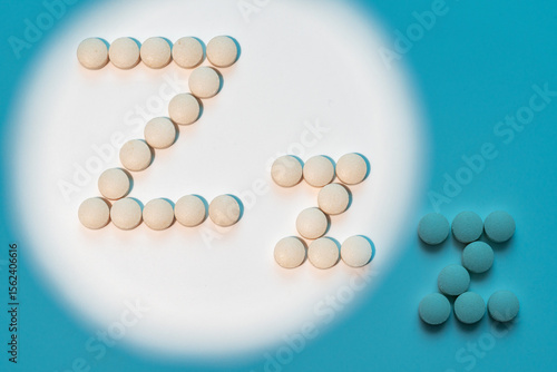 Fototapete White pills in Z shape on blue background