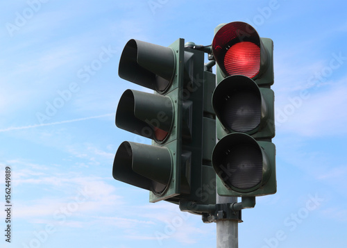 Red traffic light with the sky as background.