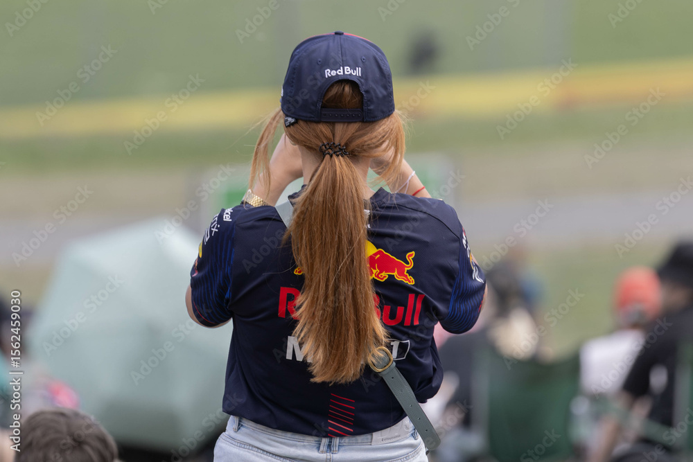 Obraz premium Spielberg, Austria: Formula 1 Red Bull Racing fan in a red shirt and a red cap on the Red Bull Ring Race track during the Austrian Grand Prix