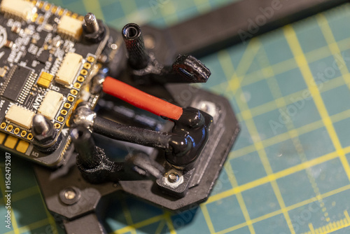 Closeup view of FPV drone circuit board on cutting mat background