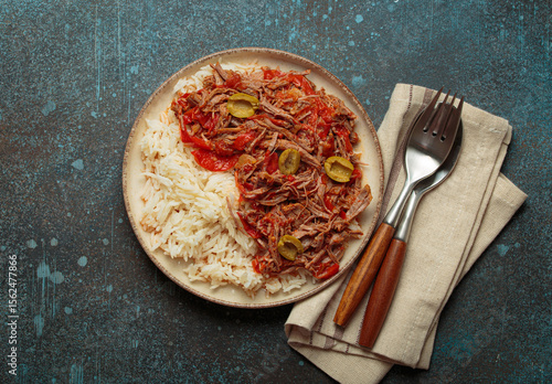 Photography Ropa vieja, a traditional Cuban dish, is served with white rice, tomato sauce, a