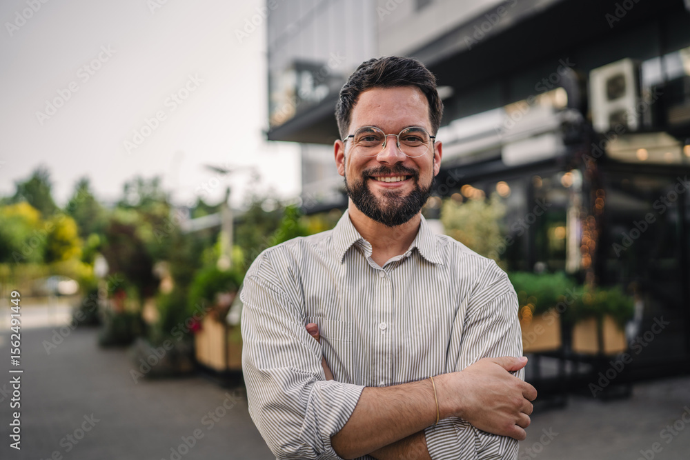 Naklejka premium Portrait of man with beard and eyeglasses stand in the street