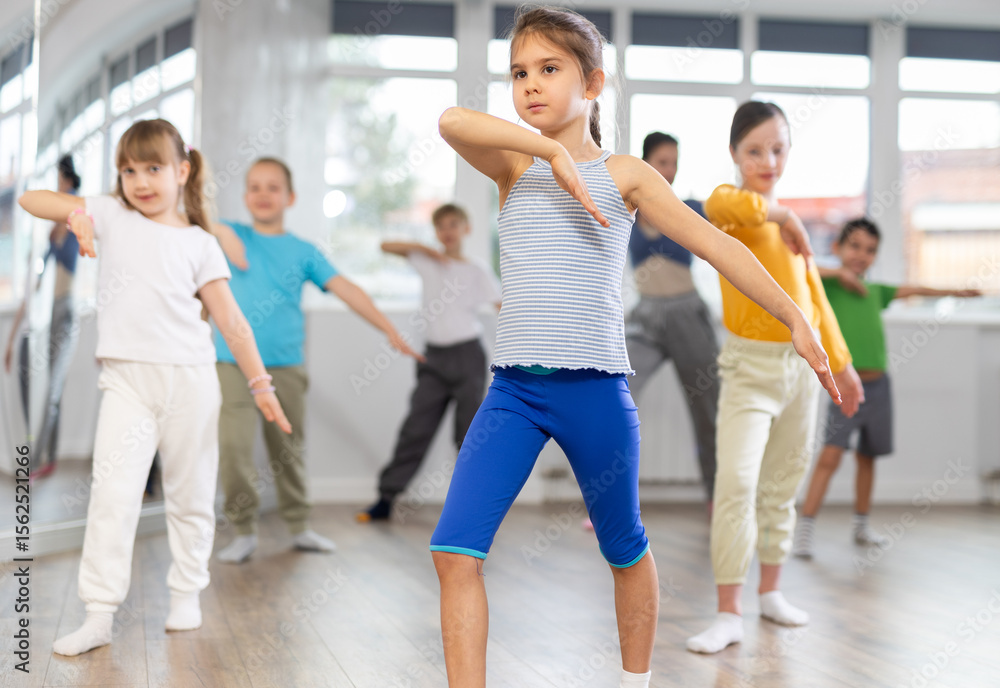 Fototapeta premium Group of boys and girls rehearsing modern dance in studio